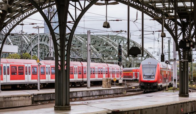 Symbolbild mit einem Regionalzug und einem Zug der S-Bahn Köln bei der Einfahrt in den Kölner Hauptbahnhof