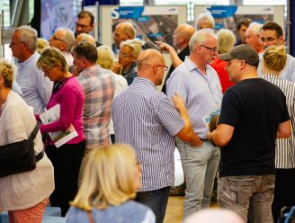 Ein Foto von der Infomesse in Bergheim. DIe Besucher unterhalten sich angeregt und betrachten die Informationstafeln.