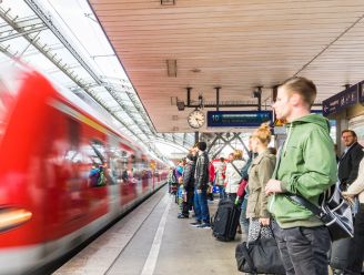 Ein Zug fährt am Bahnsteig Köln Hauptbahnhof ein. Die Fahrgäste warten am Steig.